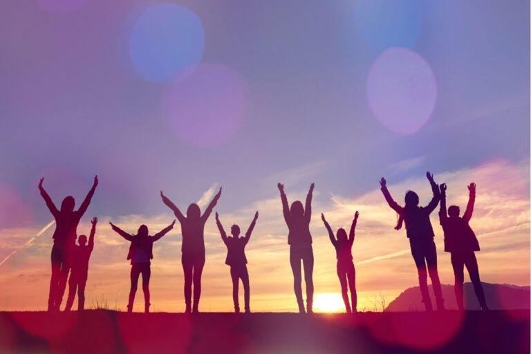 Versículos de amizade em Provérbios com grupo de amigos celebrando juntos ao pôr do sol