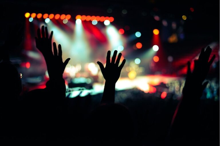 Jovens adorando com mãos levantadas em culto jovem