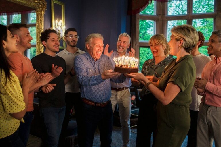 Grupo celebrando aniversário com bolo e alegria representando homenagem com versículos de aniversário para pastor