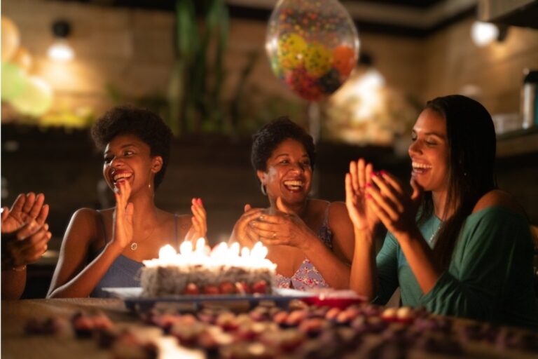Mulheres celebrando aniversário com bolo e alegria em momento especial inspirado em versículos para aniversário de esposa de pastor